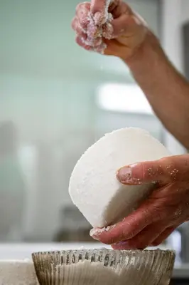 a person is holding a piece of white dough at Biohof Oberwerkstatt HAIDI in Obereggen