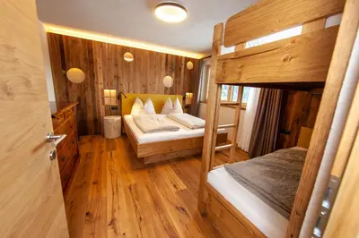 a bedroom with two bunk beds and wooden floors at Biohof Oberwerkstatt HAIDI in Obereggen