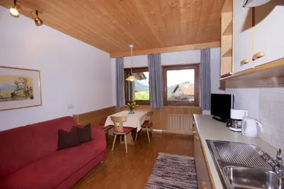 a living room with a red couch and a table at Apartments Gasserhof in Lagundo