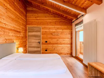 a bedroom with a large bed and a window at Apartment Larice Quadrilocale by Interhome in Livo