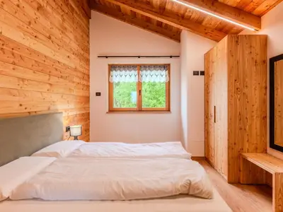 a bedroom with a bed in a wooden room at Apartment Larice Quadrilocale by Interhome in Livo