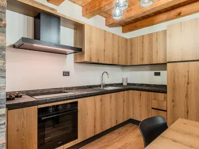 a kitchen with wooden cabinets and a sink at Apartment Larice Quadrilocale by Interhome in Livo