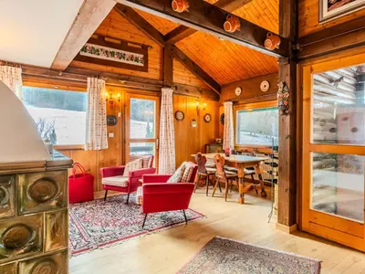 a living room with red chairs and a table at Chalet Altavista by Interhome in Ziano di Fiemme