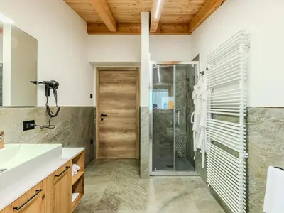 a bedroom with a bed and a window and a chair at Apartment Larice Bilocale by Interhome in Livo