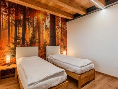 two beds in a room with a painting on the wall at Apartment Larice Bilocale by Interhome in Livo