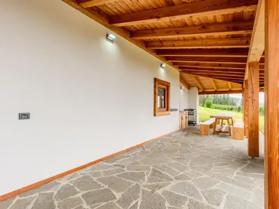 an indoor patio with a table and a wooden ceiling at Apartment Larice Bilocale by Interhome in Livo