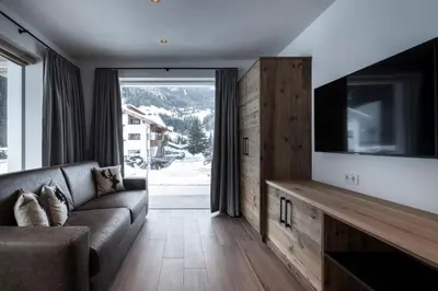 a living room with a couch and a flat screen tv at Chalet Bel Plan in Ortisei