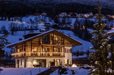 a house in the snow at night at Chalet Bel Plan in Ortisei