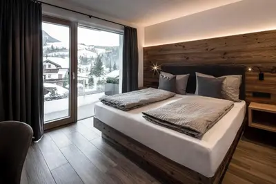 a bedroom with a large bed and a large window at Chalet Bel Plan in Ortisei