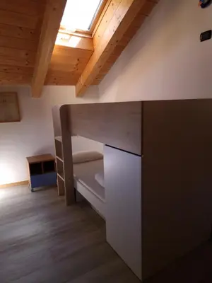 a room with a bunk bed and a desk at Cesa Pegghy in Canazei
