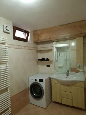 a bathroom with a washing machine and a sink at Cesa Pegghy in Canazei