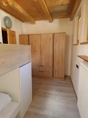 a kitchen with wooden cabinets and wooden floors at Cesa Pegghy in Canazei