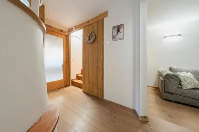 a living room with a couch and a door at Antico Fienile in Borca di Cadore