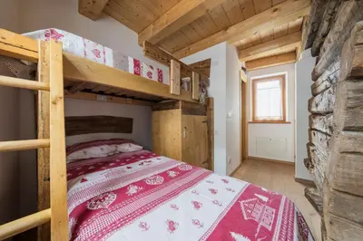 a bedroom with bunk beds in a log cabin at Antico Fienile in Borca di Cadore