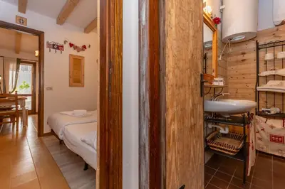 a bathroom with a bed and a sink in a room at Suite Anna in Masarè