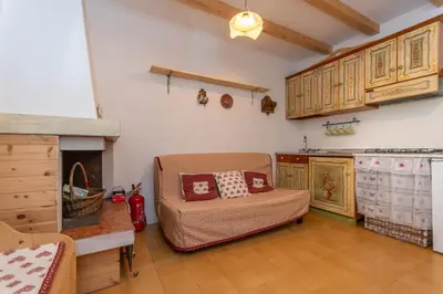 a kitchen with a couch and a fireplace in a room at Suite Anna in Masarè
