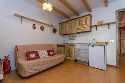a living room with a couch and a kitchen at Suite Anna in Masarè