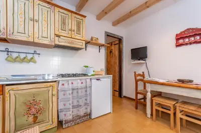 a kitchen with a stove and a white refrigerator at Suite Anna in Masarè