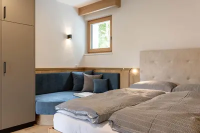 a bedroom with a bed and a blue couch at Haus Lupwald in Falzes