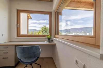 a room with a desk and a chair in front of a window at Haus Lupwald in Falzes