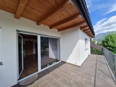 a balcony of a house with a wooden roof at Finestra sulle Vette in Tesero
