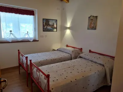 a bedroom with two beds and a window at Finestra sulle Vette in Tesero