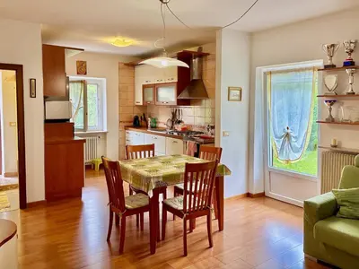 a kitchen and dining room with a table and chairs at Appartamento Olimpiadi 2026 Val di Fiemme in Panchia