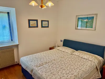 a bedroom with a bed and a window at Appartamento Olimpiadi 2026 Val di Fiemme in Panchia
