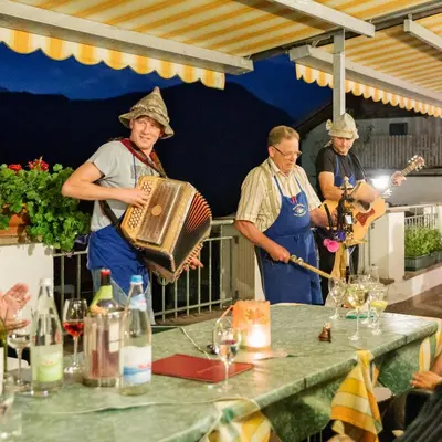 a group of men standing around a table with a instrument at Hotel Haus an der Luck in Barbiano