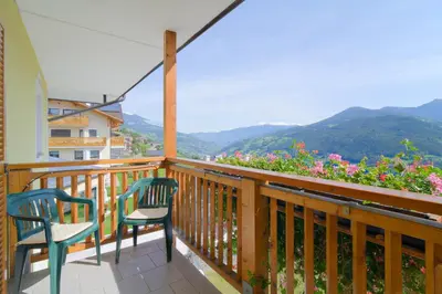 a balcony with two chairs and a view of mountains at Hotel Haus an der Luck in Barbiano