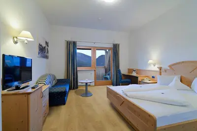 a hotel room with a bed and a television at Hotel Haus an der Luck in Barbiano