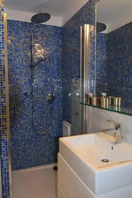 a bathroom with a sink and a shower with blue tiles at Casa di Maria Grazia in Bressanone