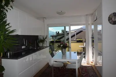 a white kitchen with a white table and chairs at Casa di Maria Grazia in Bressanone