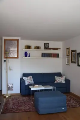 a living room with a blue couch and a table at Casa di Maria Grazia in Bressanone