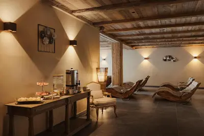 a living room with a table and chairs at Laguscei Dolomites Mountain Hotel in Arabba