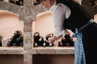 a woman standing next to a bunch of wine bottles at Laguscei Dolomites Mountain Hotel in Arabba