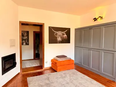 a living room with a cow picture on the wall at Castellino di Castello di fiemme in Castello di Fiemme