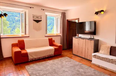 a living room with a couch and a flat screen tv at Castellino di Castello di fiemme in Castello di Fiemme