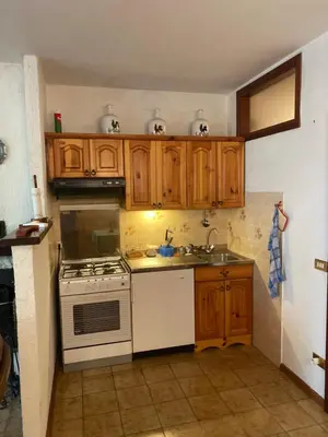 a kitchen with a white stove and wooden cabinets at EmilyNest in Vervò
