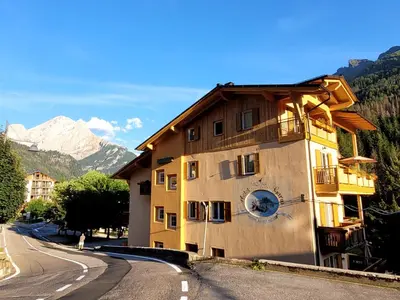 a building with a clock on the side of it at Garni B&B Mozart Nesthouse in Canazei