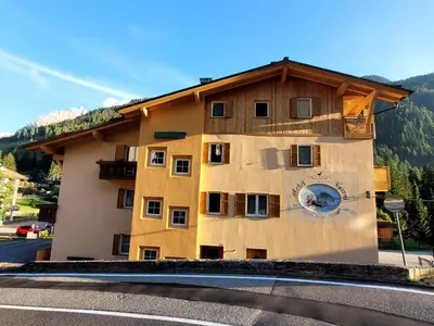 a bedroom with a bed and a flat screen tv at Garni B&B Mozart Nesthouse in Canazei
