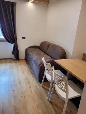 a living room with a couch and a table and chairs at Garni B&B Mozart Nesthouse in Canazei