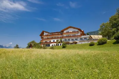 a large building on a hill in a field at Hotel Schön Aussicht in Schenna