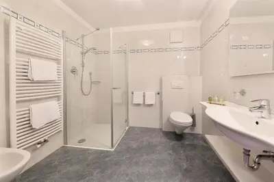 a bathroom with a shower and a toilet and a sink at Hotel Schön Aussicht in Schenna