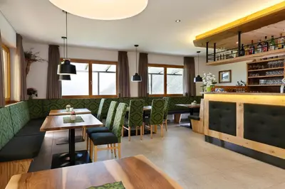 a restaurant with tables and chairs and a bar at Hotel Schön Aussicht in Schenna