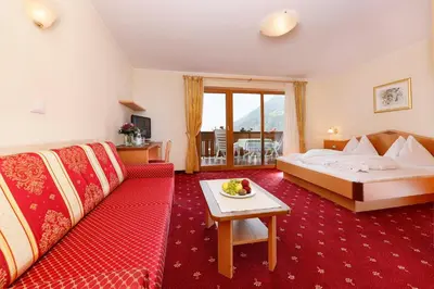 a hotel room with a bed and a couch at Hotel Schön Aussicht in Schenna