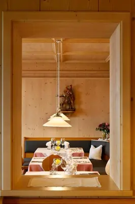 a dining room with two tables and a chandelier at Hotel Schön Aussicht in Schenna