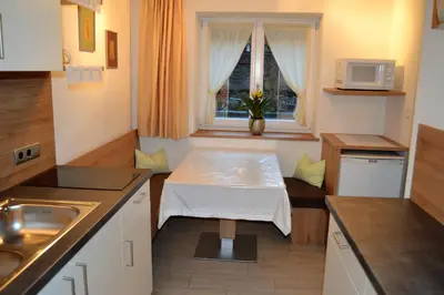 a small kitchen with a table and a window at Ferienwohnung Pramstaller in Valdaora
