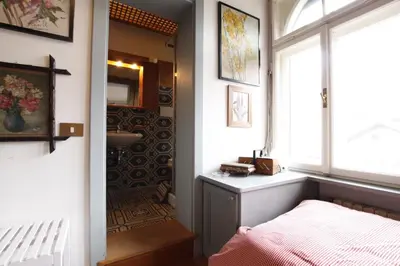 a bedroom with a bed and a sink and a window at Casa in Centro di Cortina D'Ampezzo in Cortina dʼAmpezzo
