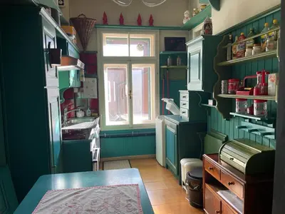 a kitchen with green walls and a window at Casa in Centro di Cortina D'Ampezzo in Cortina dʼAmpezzo